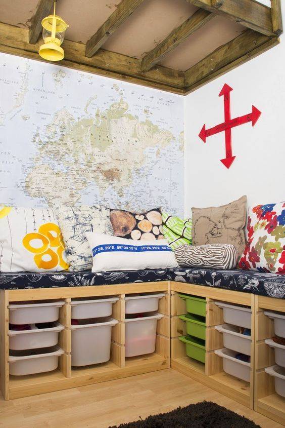 Kids bed above two Ikea Trofast units with a large map as the wall backdrop and red arrows on wall