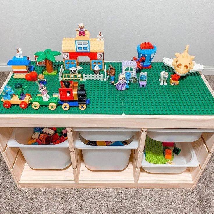 Ikea Trofast unit with green Lego table top and Lego toys on top of it