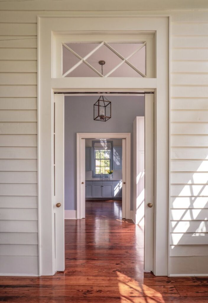 White hallway with transom window with rectangular shape and large triangles inside