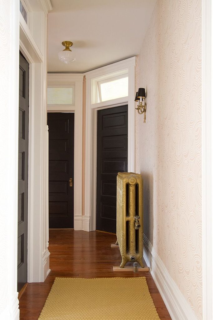 Two black doors with transom windows above in hallway