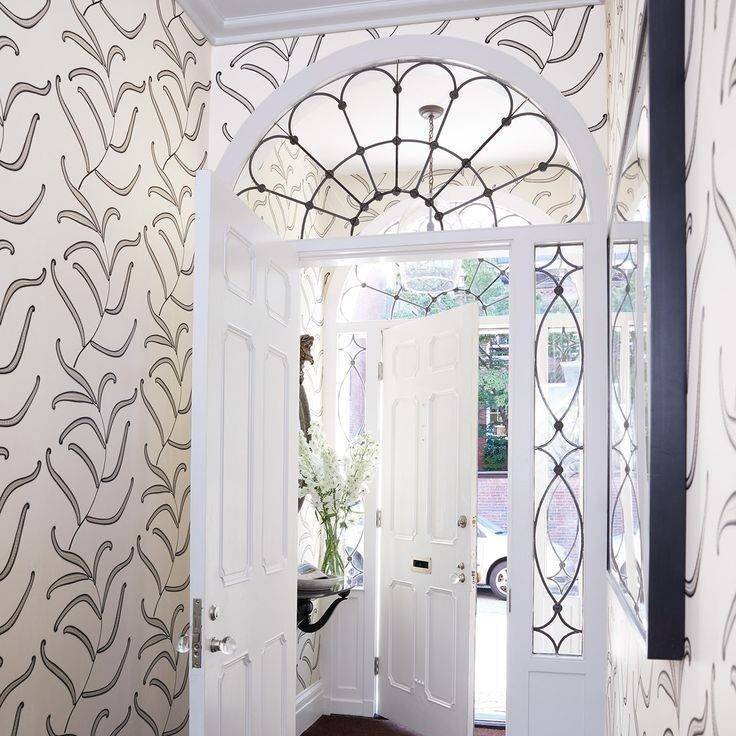 Entryway with wallpaper and arched transom window with black outline