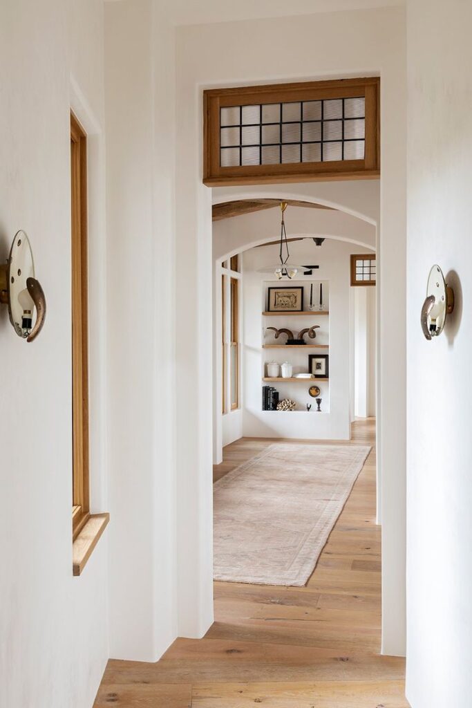 White entryway with transom window outlined by brown wood