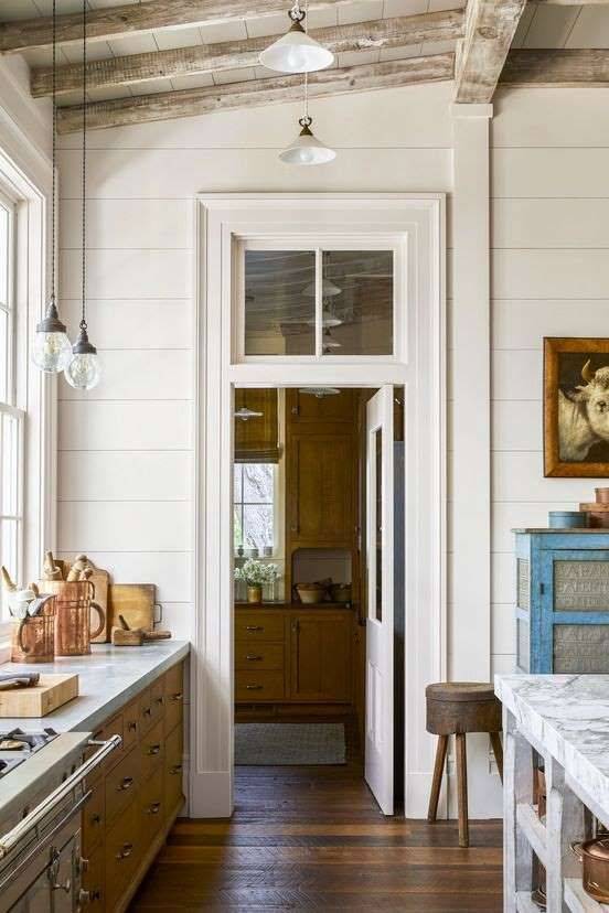 Rustic country house kitchen with doorway and white transom window above