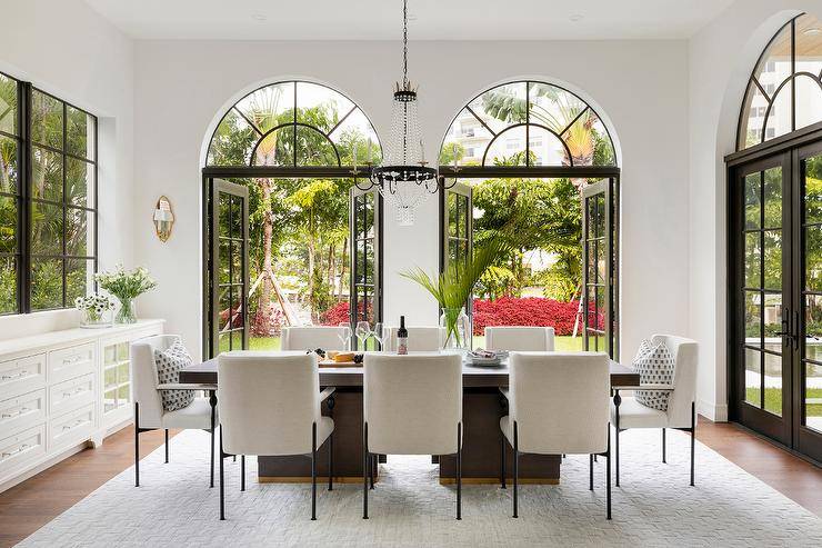 Dining room with arched transom windows against white wall