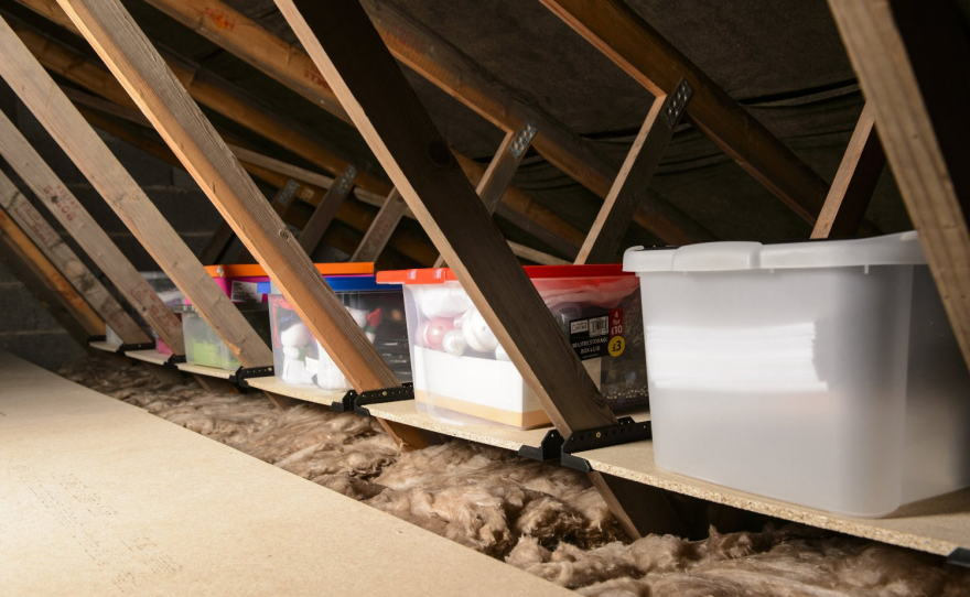 Truss shelves in attic with clear storage bins 