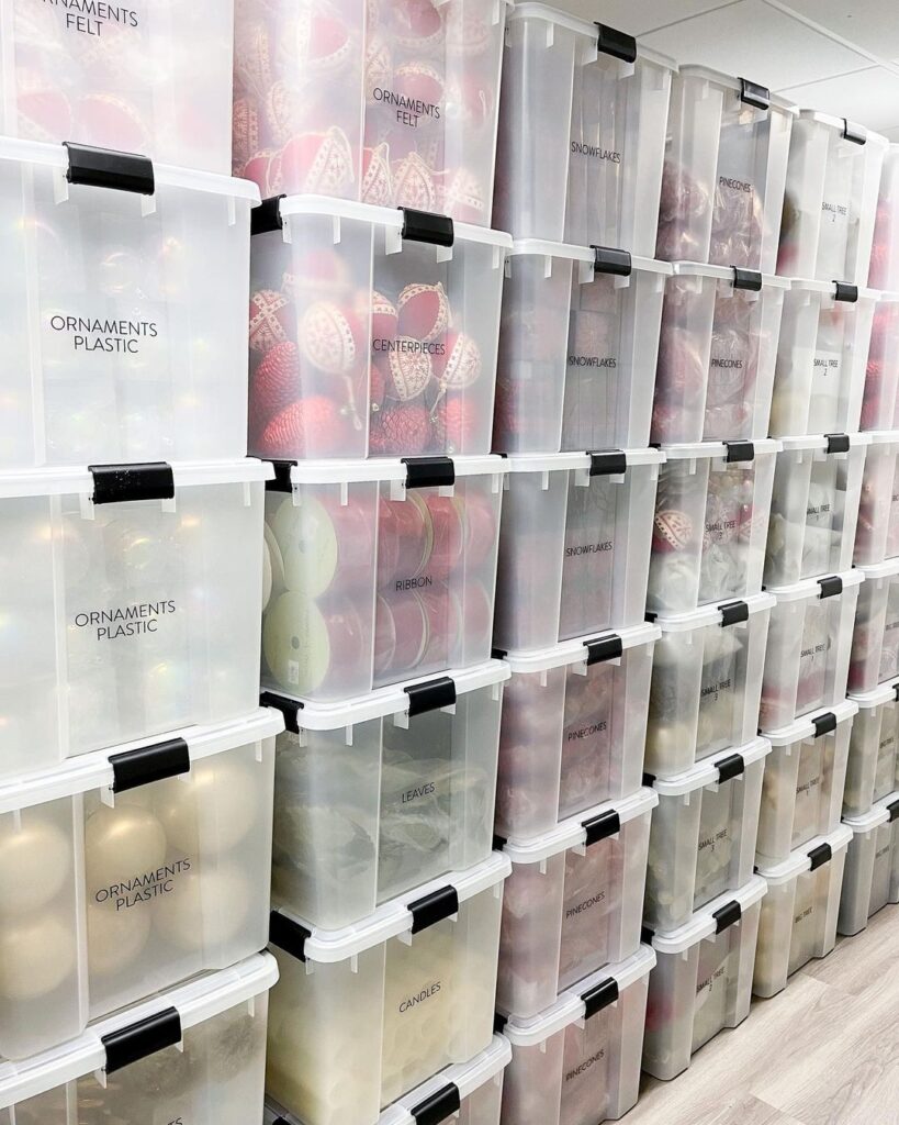 Stacked clear storage bins with Christmas ornaments inside 