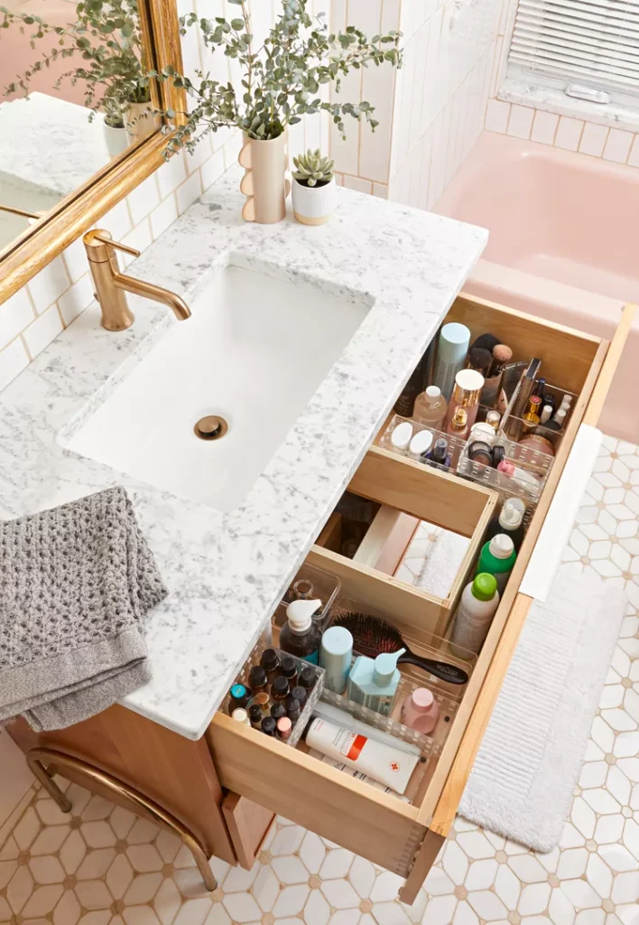 Bathroom sink with drawer that has built in organizers full of beauty products