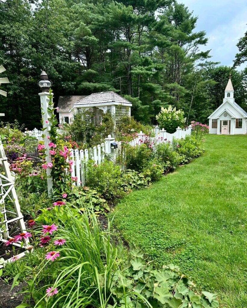 Garden with white fence and small cottage