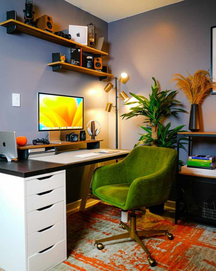 a desk with a computer and a green chair