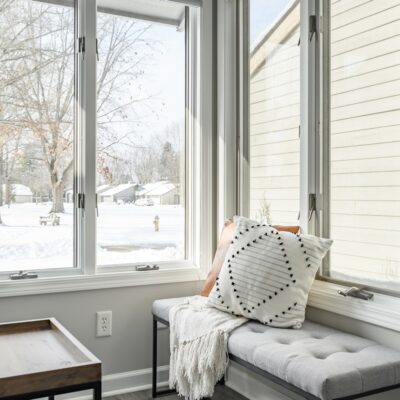 a window seat with a pillow on it in front of a window