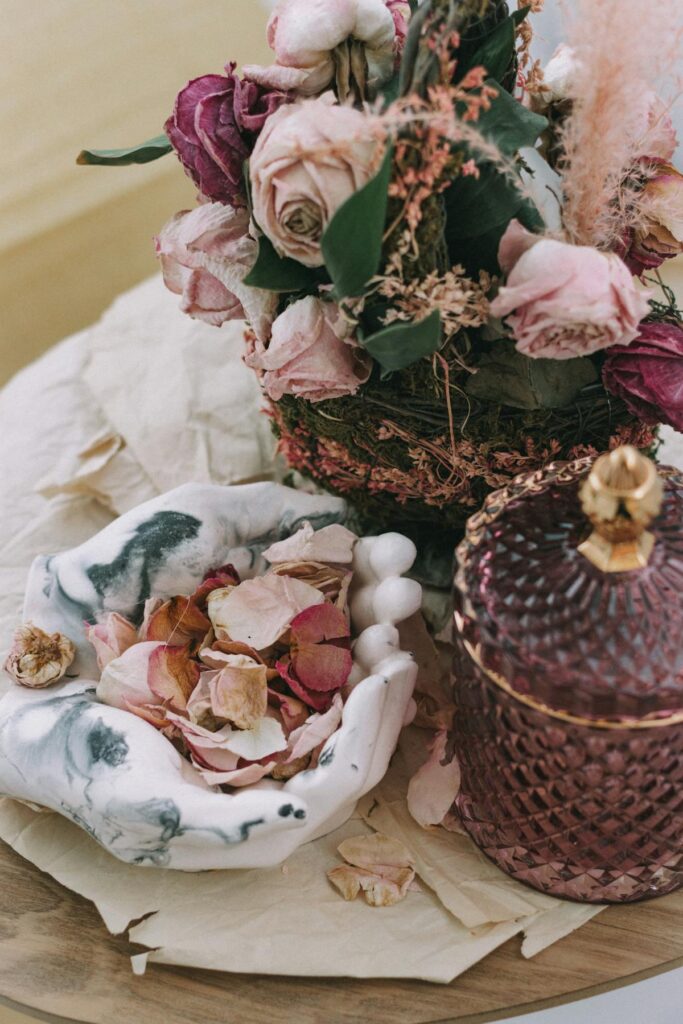 Artistic arrangement of dried roses and potpourri on a decorative table setting.