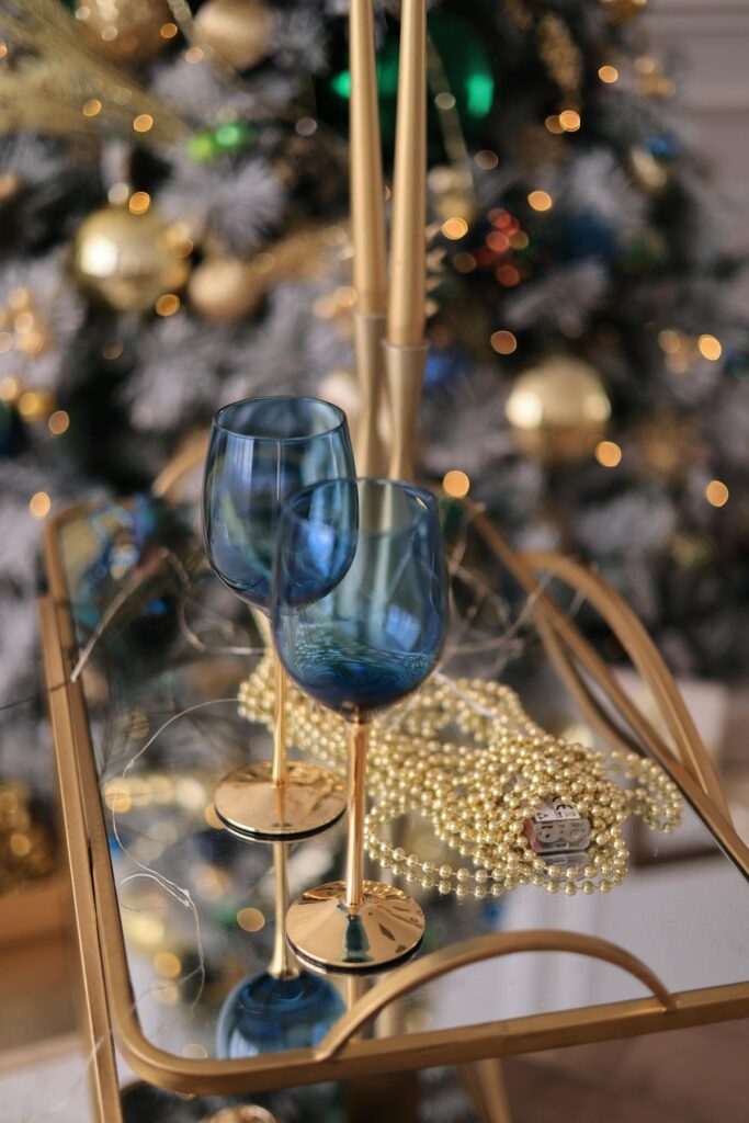 Sophisticated Christmas table decor with wineglasses and festive ornaments.