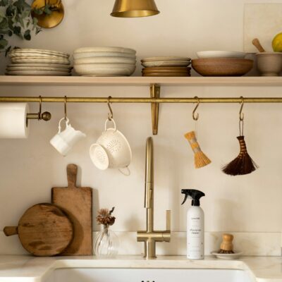 a kitchen with a white sink and gold faucet